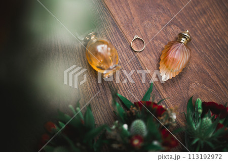 Beautiful toned picture with wedding rings against the background of a bouquet of flowers Beautiful toned picture with wedding rings against the background of a bouquet of flowers 113192972