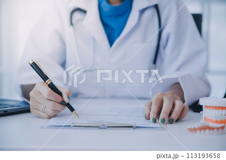 Dentists are discussing dental problems at report x-ray image on laptop screen to patients. Dentists are discussing dental problems at report x-ray image on laptop screen to patients. 113193658