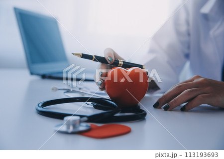 Doctor explaining heart to elderly patient. Doctor explaining the heart model. Doctors pen point to a model of the heart Doctor explaining heart to elderly patient. Doctor explaining the heart model. Doctors pen point to a model of the heart 113193693