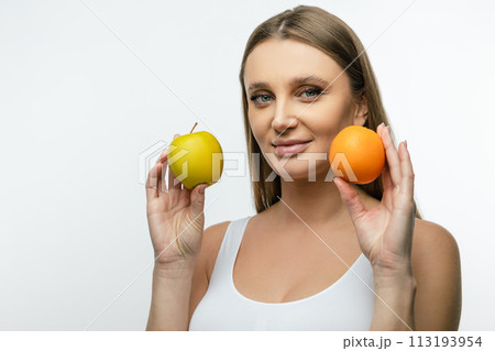 Waist up of a young woman with fruits in hands Waist up of a young woman with fruits in hands 113193954