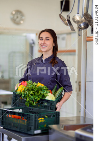 Smiling happy female chef woman holding basket with vegetable Smiling happy female chef woman holding basket with vegetable 113194084