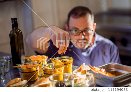 Cook serving shrimps in sweet sauce with chopsticks Cook serving shrimps in sweet sauce with chopsticks 113194088