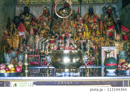 Figurines of deities in chinese Jui Tui temple in Phuket, Thailand. Shrine worship shelf with many gods, selective focus 113194364