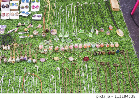 Various handicraft women's jewelry with dried flowers, clover leaf in epoxy.. Selective focus 113194539
