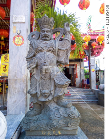 Stone statue of deity guarding entrance to temple Jui Tui Tao Boh Kaeng in Phuket, Thailand 113195459