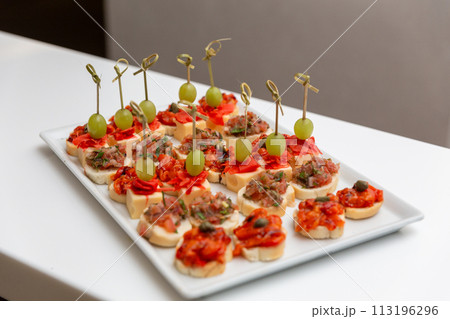 Plate with various seafood and meat canapes. 113196296