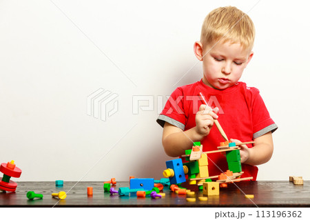 Little boy child playing with building blocks toys interior. Little boy child playing with building blocks toys interior. 113196362