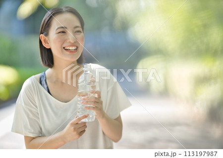 ペットボトルの水を飲むスポーツウエアの若い女性 ペットボトルの水を飲むスポーツウエアの若い女性 113197987