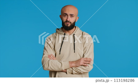 Middle eastern person acting impatient over background, tensed man waiting for something with arms crossed on camera. Arab male model being serious and punctual. Camera 1. 113198286