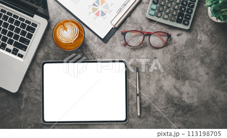 An aerial view of a modern work desk with a tablet, laptop, coffee with latte art, calculator, and report for a productive day. 113198705