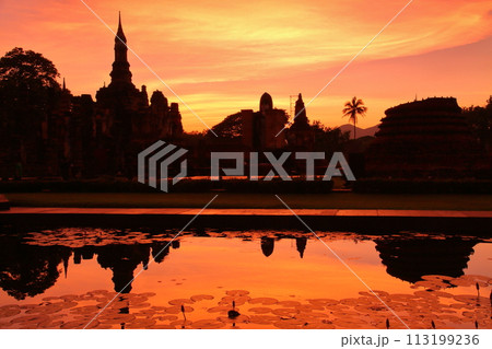 タイ北部の古都スコータイ　世界文化遺産スコータイ歴史公園内の夕焼けのワットマハタート遺跡シルエット 113199236
