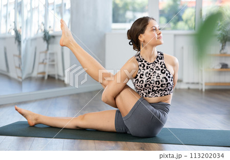 Young woman practicing yoga asanas in studio 113202034
