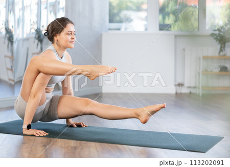 Yoga in sports gym. Girl performs bacasana asana Yoga in sports gym. Girl performs bacasana asana 113202091