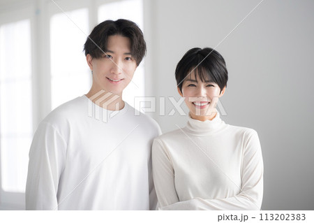 顔で寄り添う若いアジア人（日本人）リンクコーデのカップル　カメラ目線 113202383