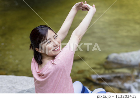 森の中でストレッチをする爽やかな女性 113202415