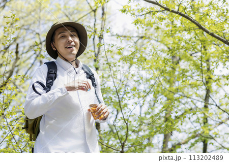 新緑のハイキングを楽しむ若い男性 113202489