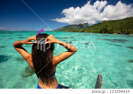 Beach travel vacation sport girl ready to snorkel in coral reefs of turquoise waters in Tahiti, French Polynesia. Image is completely unretouched. Authentic real people. Raw Image Beach travel vacation sport girl ready to snorkel in coral reefs of turquoise waters in Tahiti, French Polynesia. Image is completely unretouched. Authentic real people. Raw Image 113204434