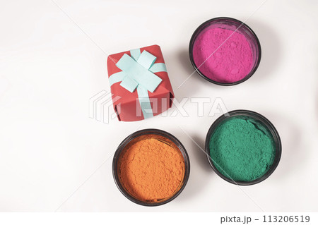 Colorful Holi powder with gift box on white background for Indian Holi festival celebration. Top view 113206519
