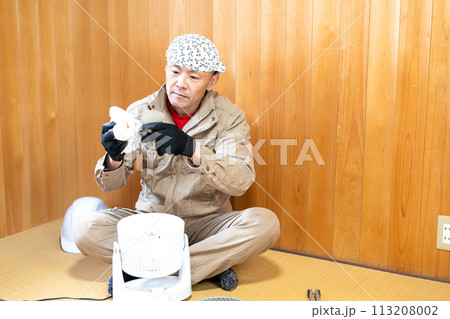 暑い季節に向けてサーキュレーターを分解掃除する仕事帰りの男性 暑い季節に向けてサーキュレーターを分解掃除する仕事帰りの男性 113208002