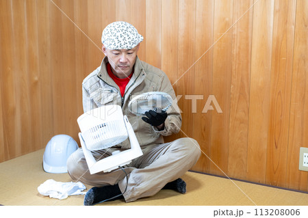 暑い季節に向けてサーキュレーターを分解掃除する仕事帰りの男性 暑い季節に向けてサーキュレーターを分解掃除する仕事帰りの男性 113208006