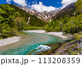 Beautiful clear river flowing towards snowcapped mountain peaks (Kamikochi, Nagano, Japan) 113208359