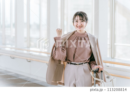 駅・ターミナル・空港のロビーでガッツポーズする女性（旅行・トラベル・応援割・旅行支援） 113208814