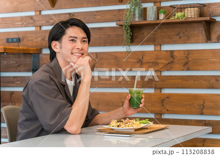 カフェでランチを食べながらグリーンスムージーを飲む若い男性(酵素・デトックス・食物繊維・健康食品) カフェでランチを食べながらグリーンスムージーを飲む若い男性(酵素・デトックス・食物繊維・健康食品) 113208838
