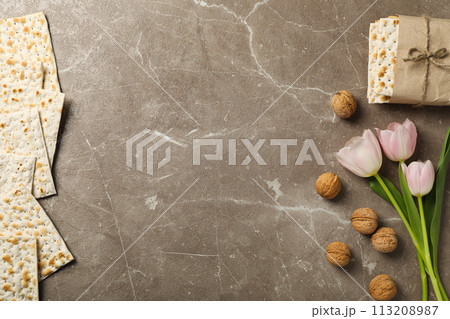 Matzo, nuts and flowers on gray background, space for text Matzo, nuts and flowers on gray background, space for text 113208987