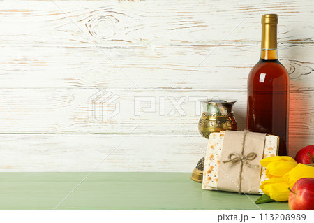 Matzo, bottle of wine, cup, flowers and apples on wooden background, space for text Matzo, bottle of wine, cup, flowers and apples on wooden background, space for text 113208989
