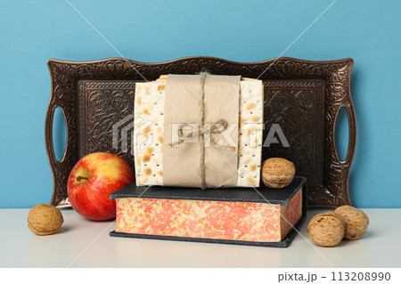Matzo, nuts, apple and Torah on blue background 113208990