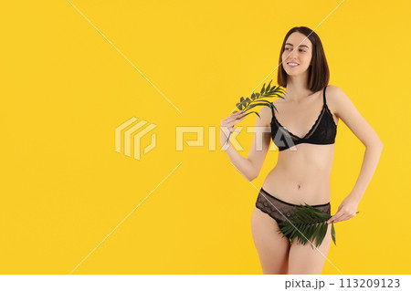 Slender girl in black underwear, with palm leaves. Slender girl in black underwear, with palm leaves. 113209123