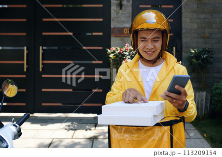 Courier checking address of customer on pizza box 113209154