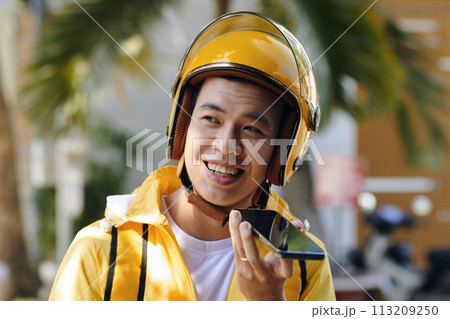 Portrait of smiling restaurant courier recording voice message for manager Portrait of smiling restaurant courier recording voice message for manager 113209250