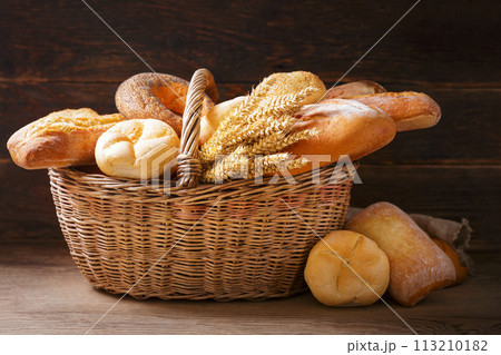 basket of fresh baked bread and wheat ears 113210182