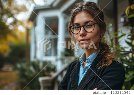 Female real estate agent standing in front of house for sale 113211543