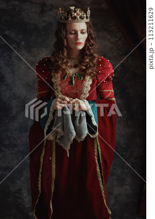pensive medieval queen in red dress with handkerchief 113211629