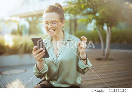 smiling modern woman worker in green blouse and eyeglasses smiling modern woman worker in green blouse and eyeglasses 113211894