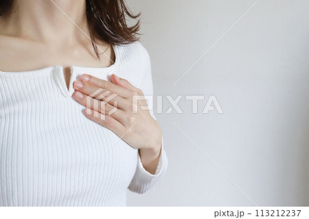 胸に手を当てる女性 113212237