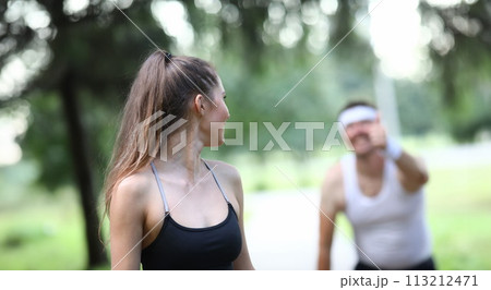 Slender girl looks back at man showing ok gesture. Slender girl looks back at man showing ok gesture. 113212471