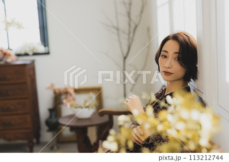 部屋のソファに座っているミドル女性 113212744