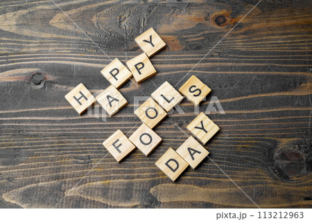 April fools day letter made by wooden cubes on a dark grunge desk. 113212963