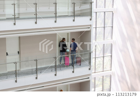 Woman hostess opening door in hotel to man and his daughter Woman hostess opening door in hotel to man and his daughter 113213179