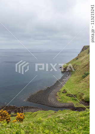 Isle of Skye coastline verdant cliffs descend to pebbled shore framed by the serenity of a soft sky Isle of Skye coastline verdant cliffs descend to pebbled shore framed by the serenity of a soft sky 113215241