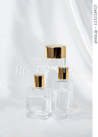 クリアガラス製化粧品ボトルとサテンの白い布 113218415