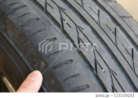 タイヤのスリップサインの三角マークを指差しチェック 113219281