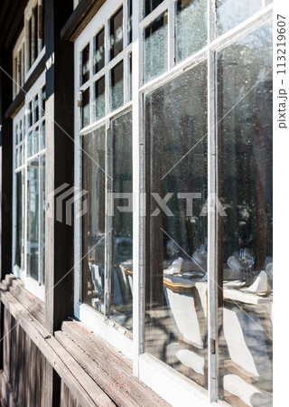 レトロな木枠のガラス窓、ワイングラスとテーブルセッティング 113219607