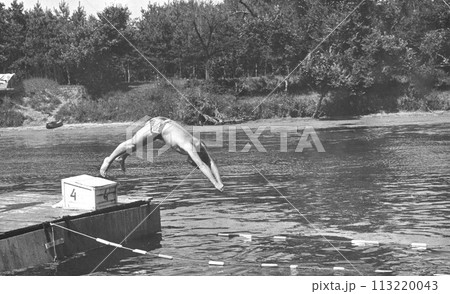 Retro photo of a young man jumping into the river. THE USSR. 70s of the 20th century. Retro photo of a young man jumping into the river. THE USSR. 70s of the 20th century. 113220043