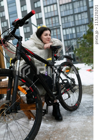 Woman Sitting on Bench Next to Bike Woman Sitting on Bench Next to Bike 113220201