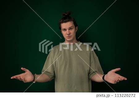 Man Standing in Front of Green Wall Holding Out Hands Man Standing in Front of Green Wall Holding Out Hands 113220272