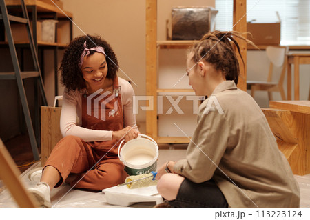 Pouring white paint in plastic tray Pouring white paint in plastic tray 113223124